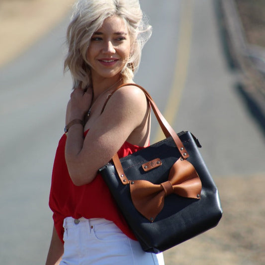 jani tote bag in black with tan bow and tan straps