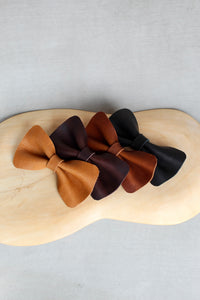 picture of leather bow ties in tan and dark brown and black and cognac